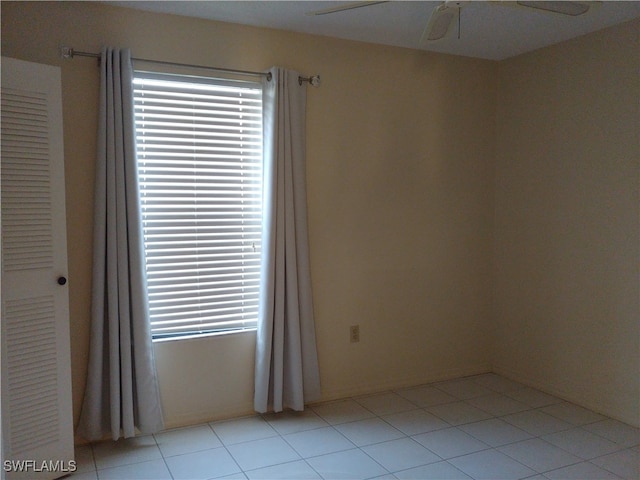 tiled spare room featuring ceiling fan