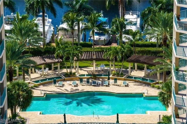 view of swimming pool featuring a pergola and a water view