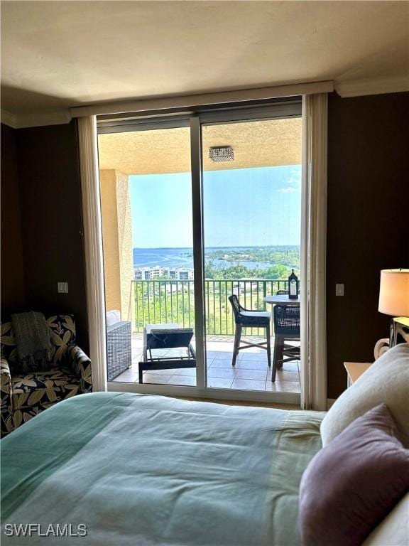 bedroom featuring access to exterior, a water view, and floor to ceiling windows