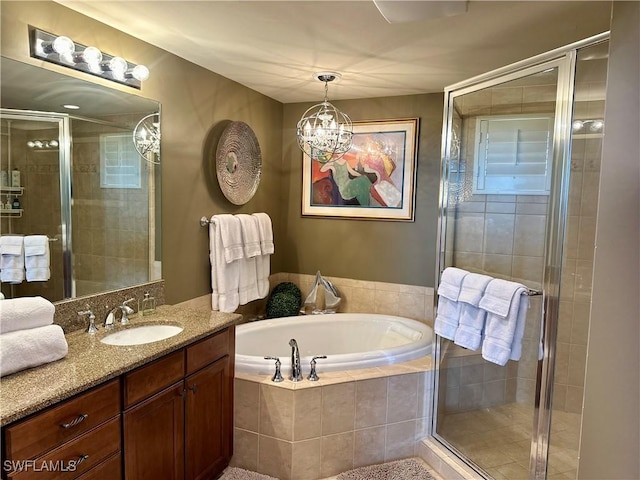 bathroom with vanity, shower with separate bathtub, and a chandelier