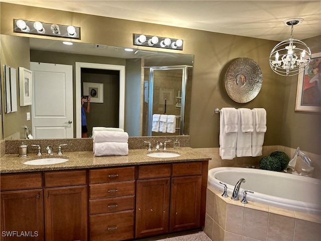 bathroom with vanity, independent shower and bath, and an inviting chandelier