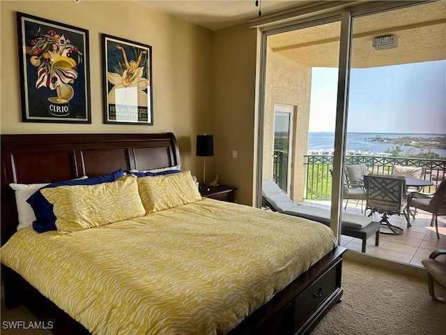 bedroom with access to exterior, carpet floors, and a water view