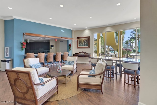 living room with recessed lighting, baseboards, wood finished floors, and crown molding