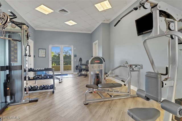 exercise area featuring visible vents, ornamental molding, french doors, wood finished floors, and a paneled ceiling