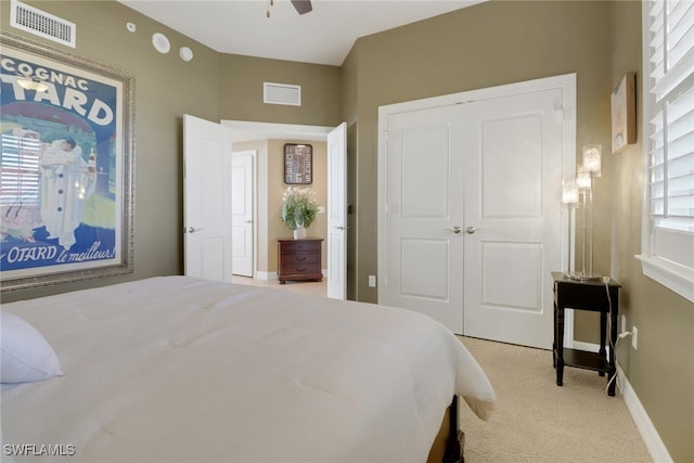 carpeted bedroom featuring visible vents, baseboards, and a closet