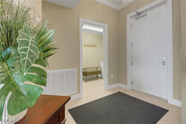 tiled foyer entrance with visible vents, baseboards, and ornamental molding