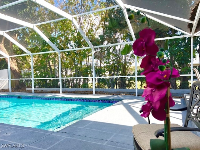 view of swimming pool with glass enclosure and a patio area