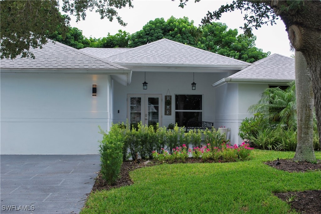 exterior space featuring a yard and french doors