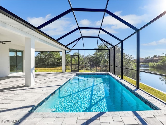 view of pool featuring a patio, a water view, and glass enclosure