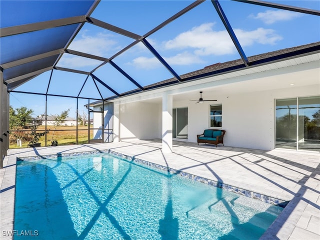 view of swimming pool with a patio, glass enclosure, and ceiling fan