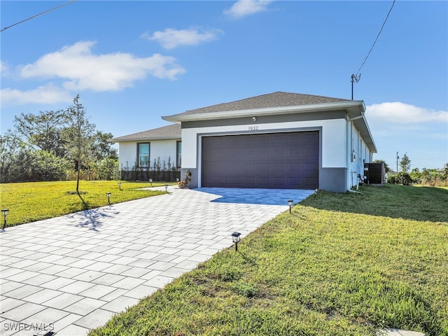 view of front of home featuring central AC, a front lawn, and a garage