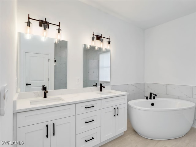 bathroom featuring shower with separate bathtub, vanity, and tile walls