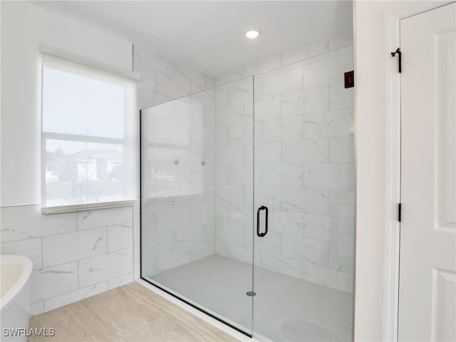 bathroom with tile patterned floors, tile walls, and independent shower and bath