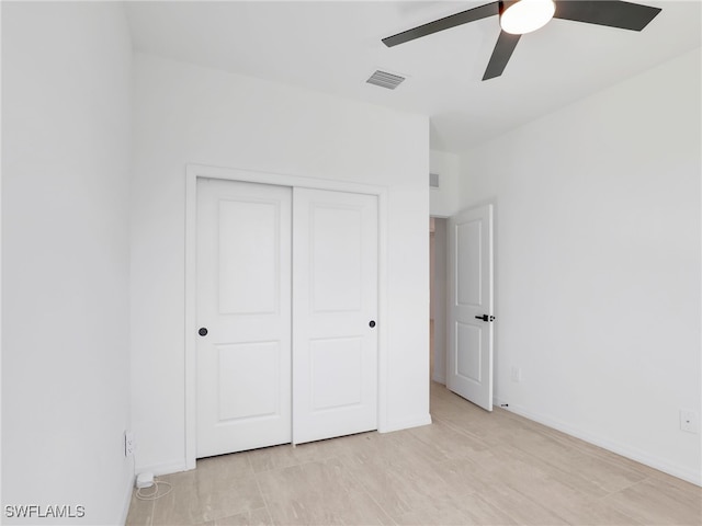 unfurnished bedroom with ceiling fan and a closet