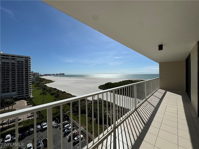 balcony with central AC, a water view, and a beach view