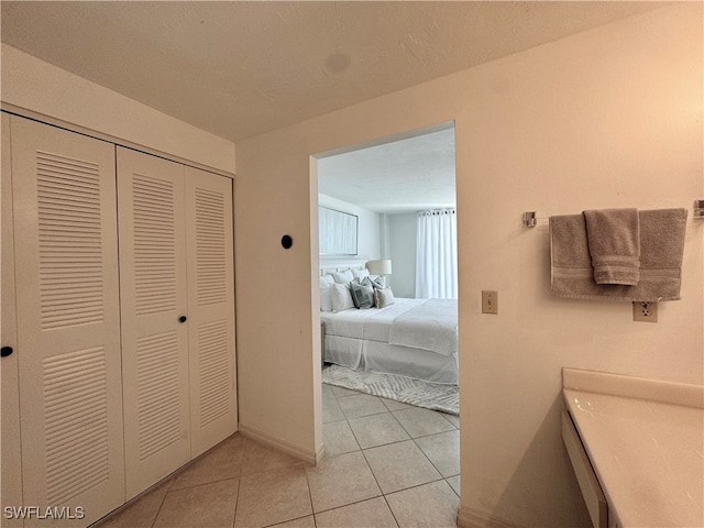 bedroom featuring light tile patterned floors and a closet