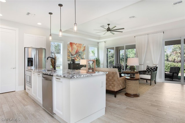 kitchen with white cabinetry, dishwasher, light stone counters, light hardwood / wood-style flooring, and an island with sink