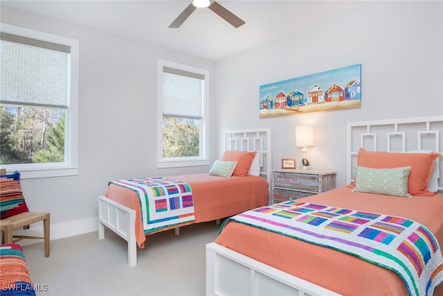 carpeted bedroom featuring multiple windows and ceiling fan