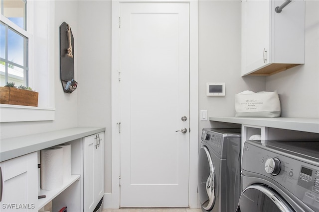 washroom with washer and clothes dryer and cabinets