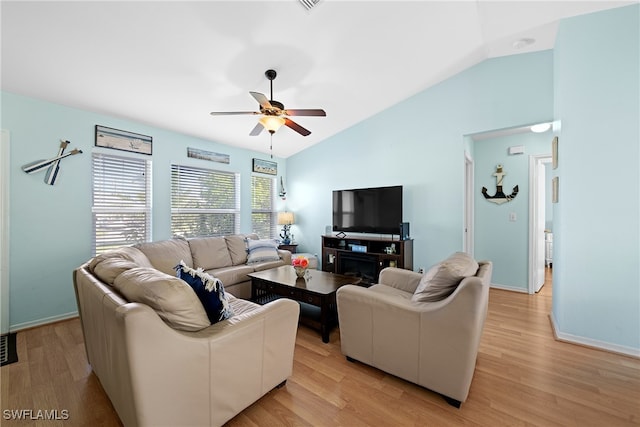 living room featuring ceiling fan, vaulted ceiling, and light hardwood / wood-style flooring