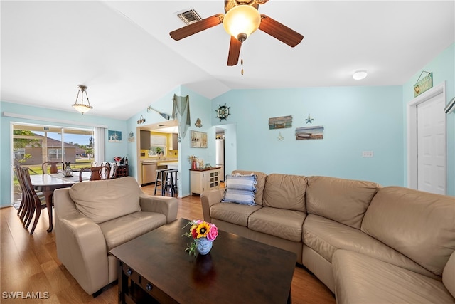 living room with lofted ceiling, ceiling fan, and light wood-type flooring