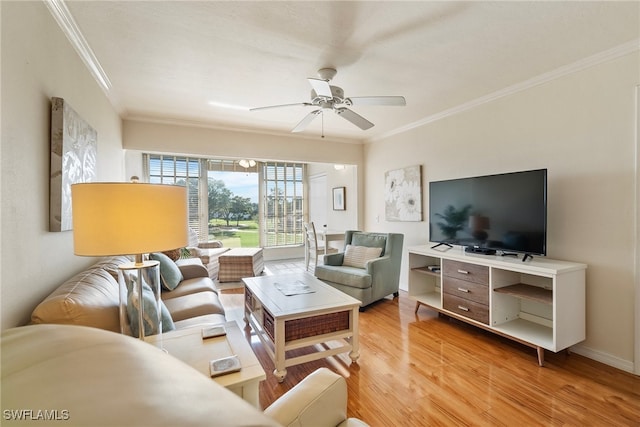 living room with hardwood / wood-style flooring, ceiling fan, and crown molding