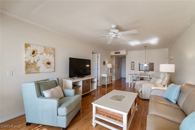 living room featuring ceiling fan, wood-type flooring, and ornamental molding