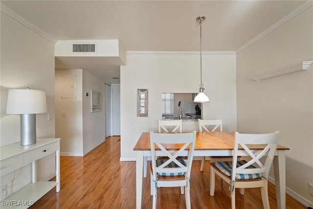 dining room featuring light hardwood / wood-style floors and crown molding