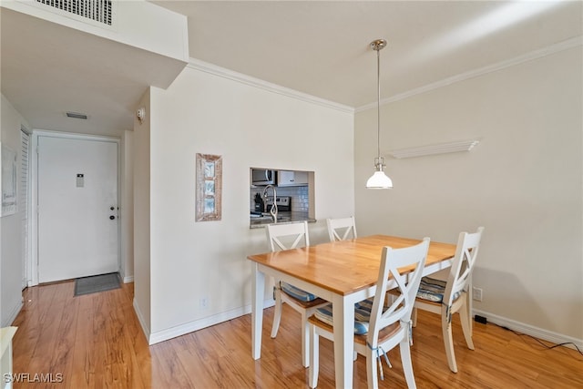 dining room featuring ornamental molding and hardwood / wood-style flooring