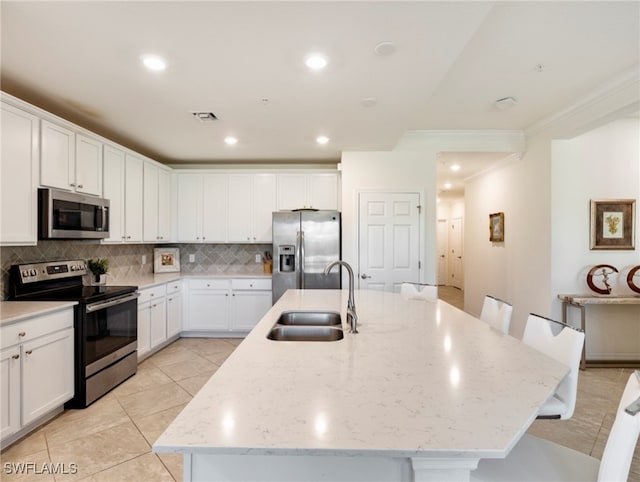 kitchen featuring a kitchen bar, appliances with stainless steel finishes, a kitchen island with sink, and sink