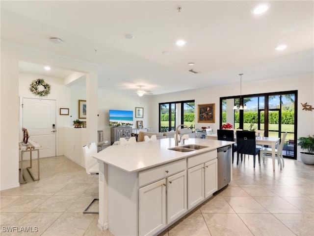 kitchen featuring pendant lighting, dishwasher, a kitchen island with sink, white cabinets, and sink