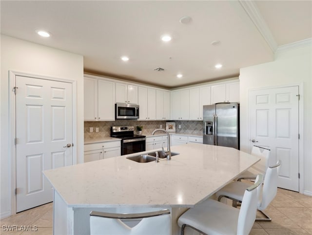 kitchen featuring a kitchen island with sink, white cabinets, sink, light tile patterned flooring, and stainless steel appliances