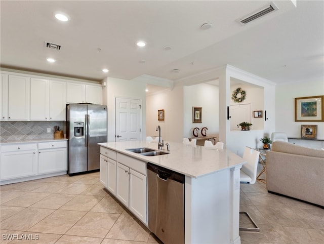 kitchen with sink, stainless steel appliances, backsplash, an island with sink, and white cabinets