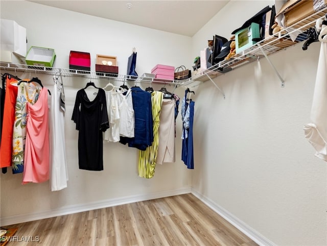 walk in closet with light hardwood / wood-style floors