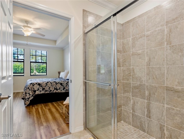 bathroom with ceiling fan, ornamental molding, a shower with shower door, and hardwood / wood-style flooring