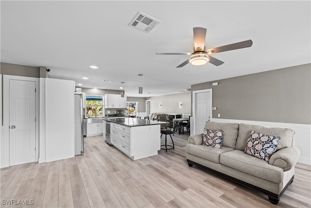 living room with ceiling fan and light wood-type flooring