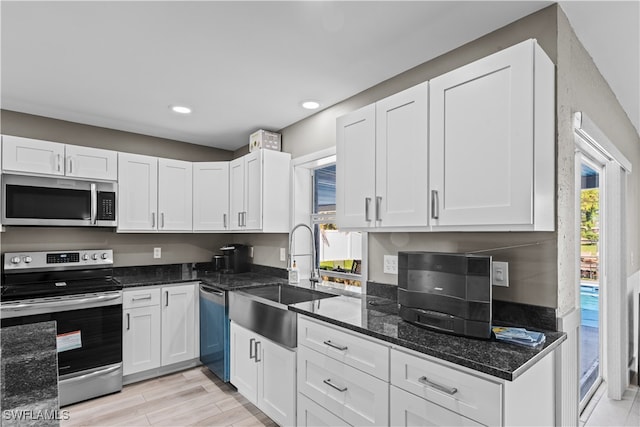 kitchen with white cabinetry, plenty of natural light, stainless steel appliances, and sink