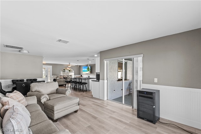 living room with ceiling fan and light hardwood / wood-style flooring