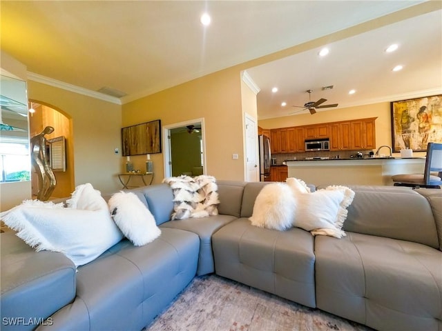 living room featuring light hardwood / wood-style floors, ceiling fan, and crown molding