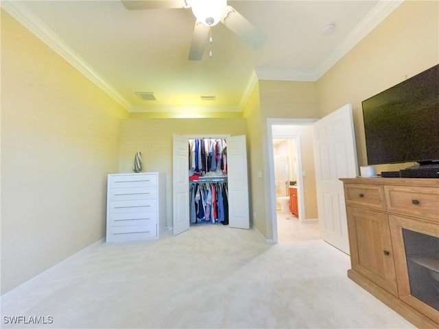 carpeted bedroom with a closet, crown molding, and ceiling fan