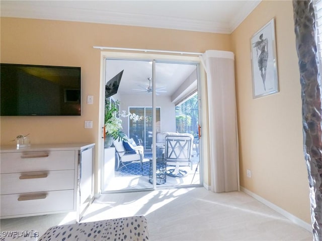 entryway featuring light carpet, ceiling fan, and ornamental molding