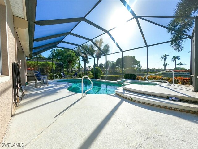 view of swimming pool with a patio and glass enclosure