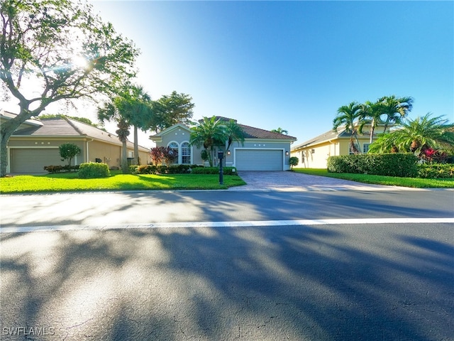 ranch-style house with a garage and a front lawn