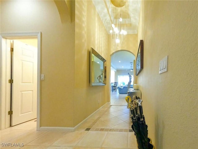 hallway with light tile patterned floors and ornamental molding