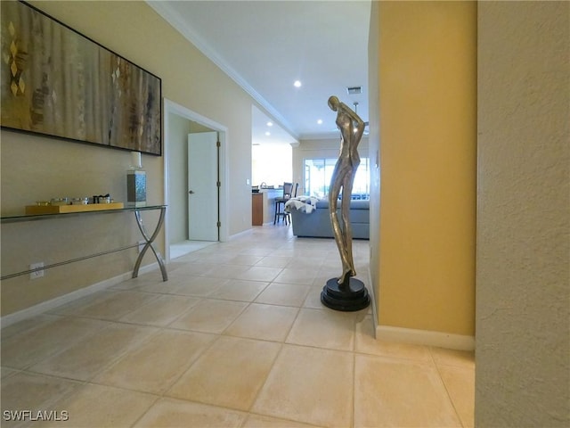 corridor with ornamental molding and light tile patterned floors