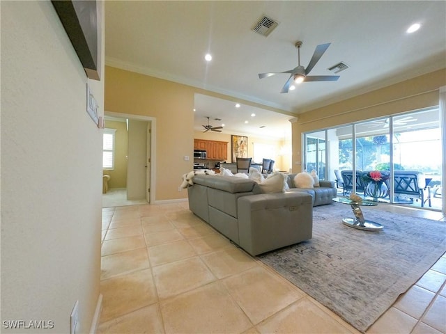 living room featuring light tile patterned floors, crown molding, ceiling fan, and a healthy amount of sunlight