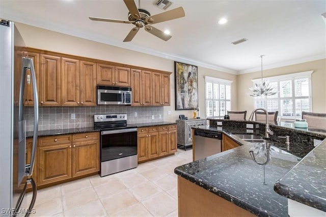 kitchen with stainless steel appliances, backsplash, dark stone counters, pendant lighting, and ornamental molding