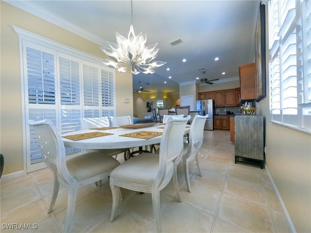 tiled dining space featuring ornamental molding and a chandelier