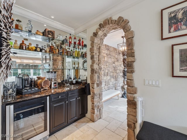 bar with dark stone countertops, wine cooler, crown molding, and sink