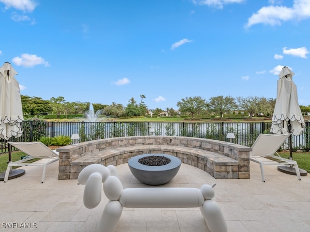 view of patio / terrace with a water view and an outdoor fire pit